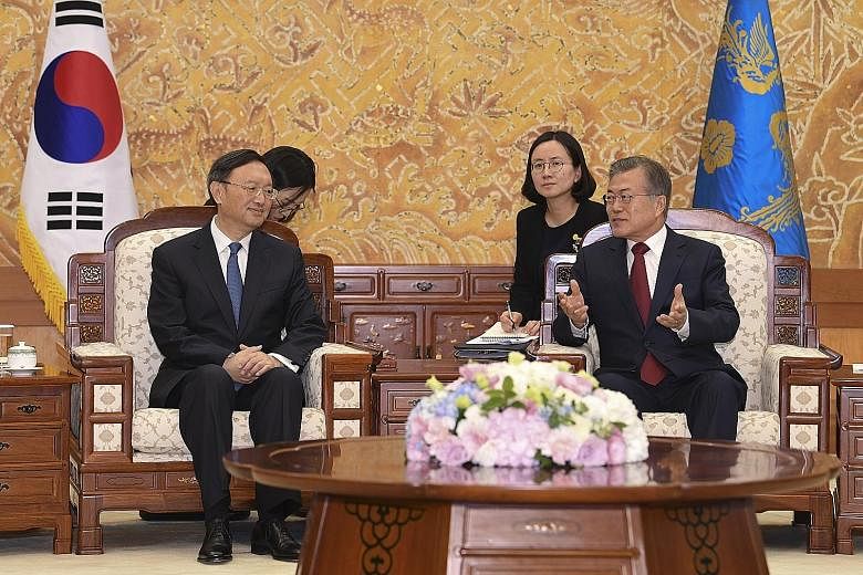 South Korea's President Moon Jae In (right) with top China diplomat Yang Jiechi in Seoul yesterday.