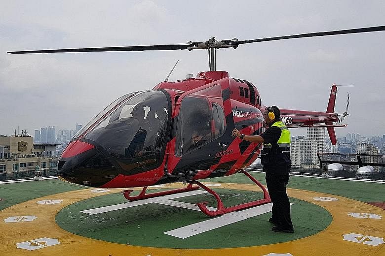 Left: Beating a traffic jam in Jakarta high above in a Helicity helicopter. Above: Arriving in style on the rooftop helipad at Shangri-La hotel. Below: Whitesky Aviation launched helicopter-taxi service Helicity which allows customers to book rides f