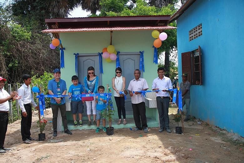 The new playground that donors from Holiday for Hope helped to fund at Ta Snae Primary School in Siem Reap. Ms Jilly Wang (in blue) with her sons Lim Wei Chen (left) and Lim Wei Kheng at a ceremony to mark the opening of new toilets at Ta Snae Primar