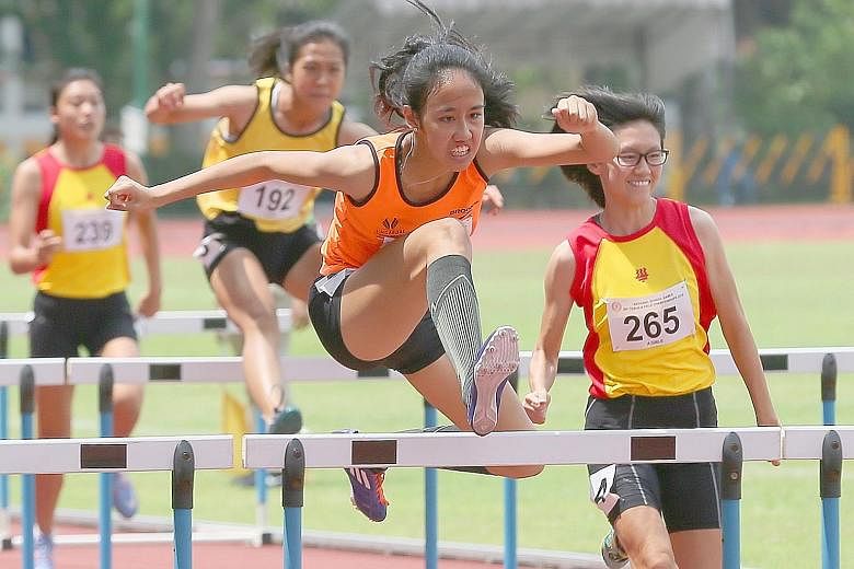 Left: Chong Wei Guan of the Singapore Sports School says his record-breaking feat was the result of hard work put in with his coach, Pedro Cunha. Right: Tia Louise Rozario of the Singapore Sports School retaining the girls' A Division 110m hurdles in