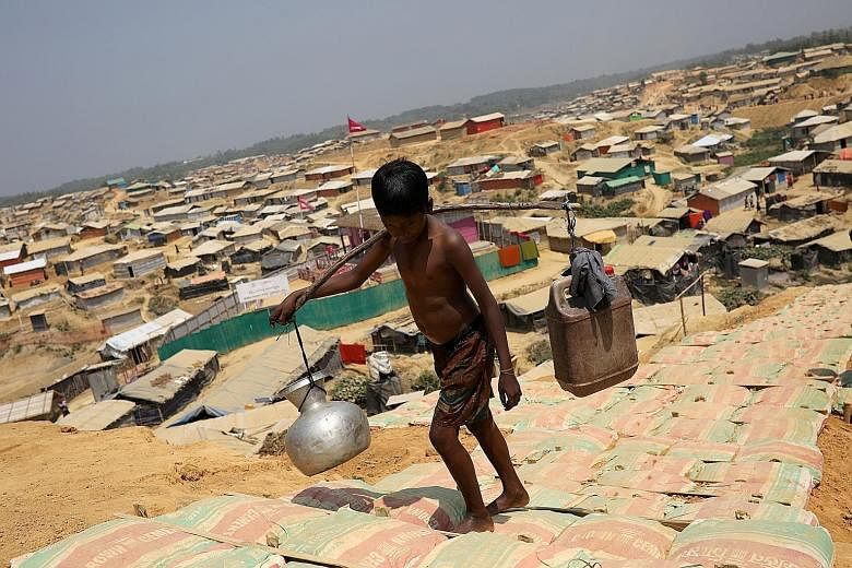 A Rohingya boy carrying water at the Kutupalong refugee camp in Cox's Bazar, Bangladesh. The country has agreed to a visit by Minister for Social Welfare, Relief and Resettlement Win Myat Aye.