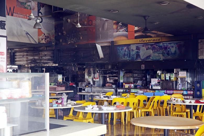 Two men were hurt when fire broke out at a coffee shop next to the Bishan bus interchange on Monday night. Yesterday morning, all the stalls in the coffee shop were closed. The building itself appeared intact although black soot covered parts of an e