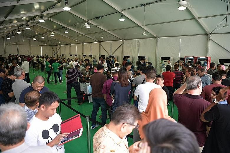 Former Uber drivers queueing on Monday to register with Grab at Midview City in Sin Ming, where Grab's driver centre is located.