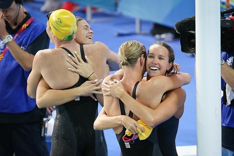 Emma McKeon (right) embracing Bronte Campbell as Shayna Jack does the same with Cate Campbell after the Australian quartet ended the day at the Optus Aquatic Centre by winning the 4x100m freestyle relay in 3min 30.05sec, a world record. It was the ho
