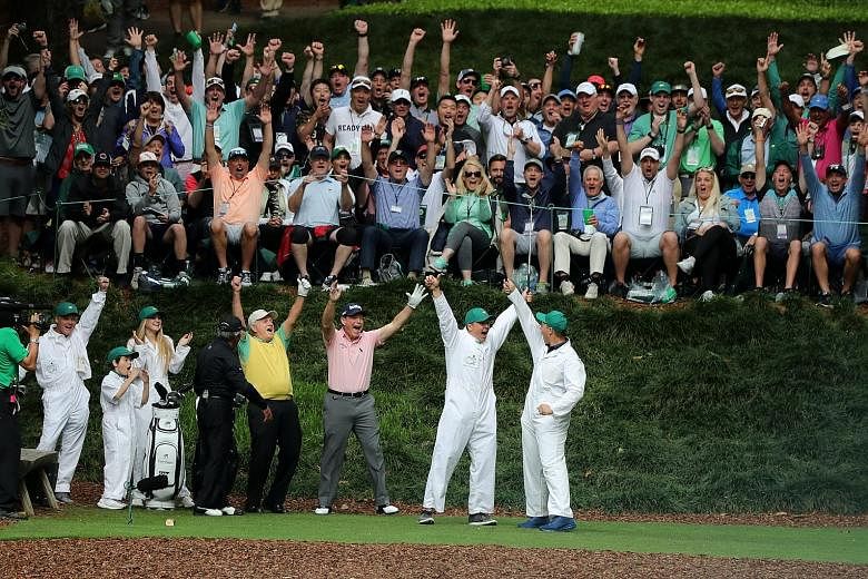 Jack Nicklaus (in yellow) celebrating after his grandson Gary made a hole-in-one on the ninth and final hole during the Masters Par-3 contest at Augusta National, as Gary Player (in black) and eventual winner Tom Watson join in the celebrations.