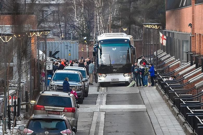 US diplomats and their families who have been expelled from Russia prepare to board a bus to leave the American Embassy compound in Moscow yesterday. The nerve agent attack in England sparked mass expulsions and a decision by Britain and a few of its