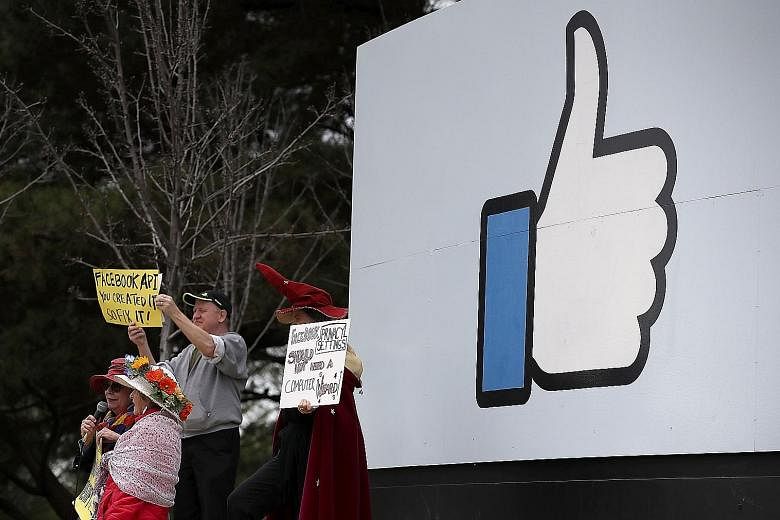 Protesters (above and below right) outside Facebook headquarters in Menlo Park, California, on Thursday calling for better consumer protection and online privacy in the wake of Cambridge Analytica's unauthorised access to the data of up to 87 million