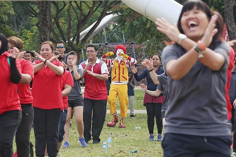 More than 100 McDonald's employees taking part in a mass workout session at West Coast Park yesterday morning. McDonald's is GetActive Singapore's first partner for this year, and plans to hold family-targeted fitness sessions at several of its outle