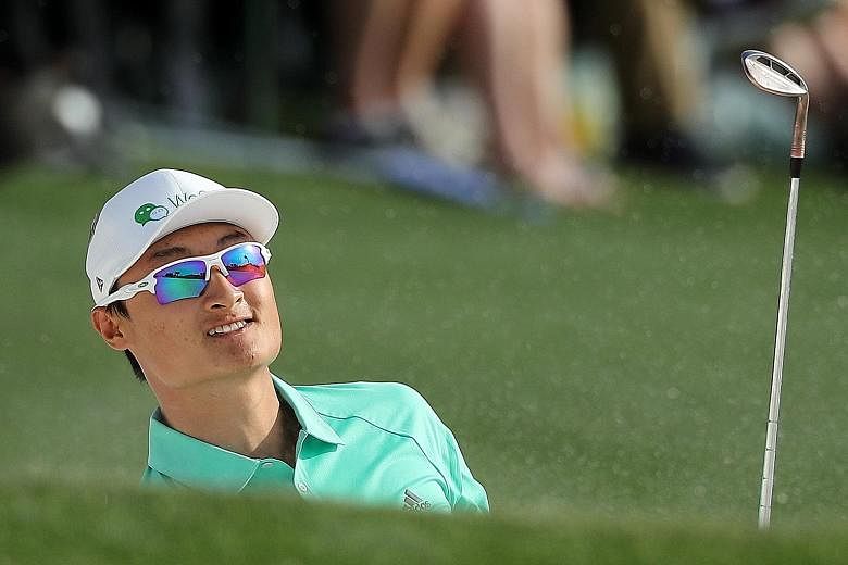 China's Li Haotong watches his chip shot land on the 18th green during the first round of the Masters tournament at the Augusta National Golf Club on Thursday. The 22-year-old's three-under 69 catapulted him to tied fourth.