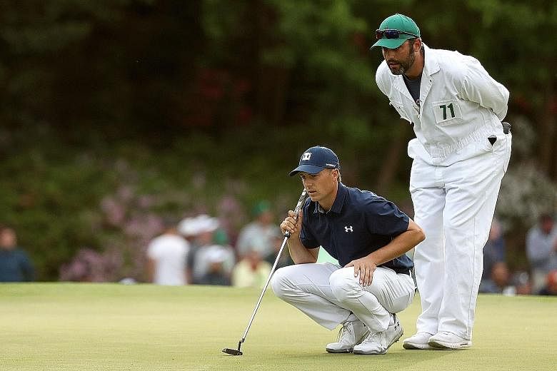 Jordan Spieth and caddie Michael Greller line up a putt during the opening round of the Masters at Augusta National Golf Club on Thursday. The American carded a six-under 66 to take the first-round lead.