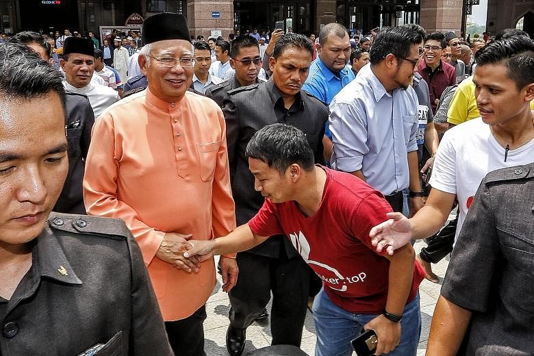 Prime Minister Najib Razak with supporters after Friday prayers in Putrajaya yesterday. Analysts say support from the lower income is likely due to the Najib administration pouring billions into welfare programmes such as direct cash aid, subsidies f