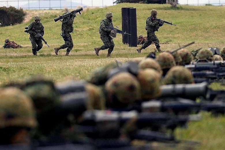Japanese troops from the Ground Self-Defence Force's Amphibious Rapid Deployment Brigade in a drill on the south-western island of Kyushu yesterday.