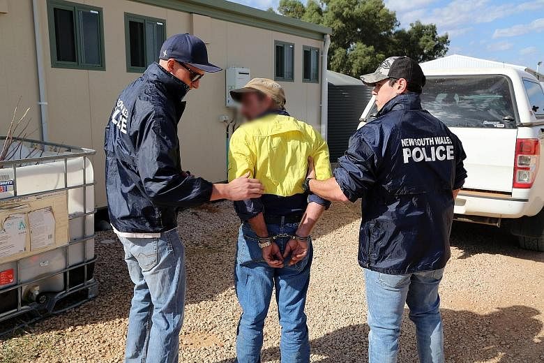 A man being arrested by police officers following a multi-state investigation into suspected child abuse in New South Wales, Australia. Children with misshapen features were found on a rural property where the incestuous family lived.