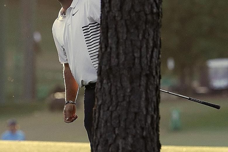 American Patrick Reed looking out from behind a tree on the 17th fairway during the second round of the Masters golf tournament on Friday.