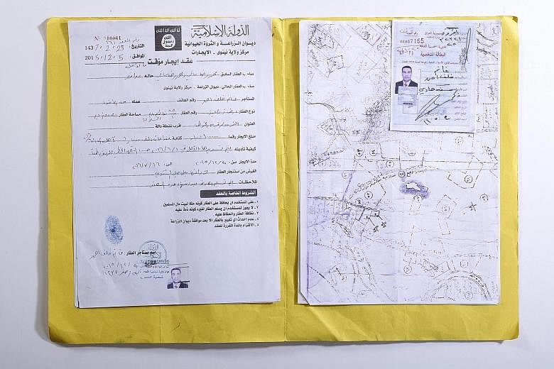 (Left) One of the land leases which the Islamic State in Iraq and Syria had stolen from members of religious groups it chased out. (Far left) Paperwork littering Mosul's bombed-out Ministry of Agriculture last September.