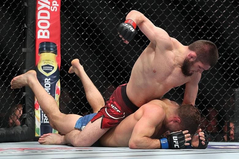 Khabib Nurmagomedov throwing a punch at Al Iaquinta in their UFC lightweight championship bout that he won convincingly.
