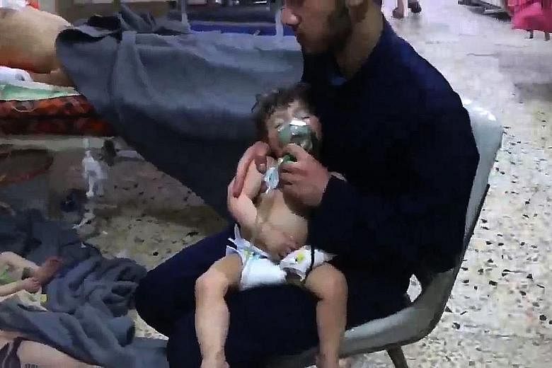 A volunteer holding an oxygen mask over a child's face at a hospital following an alleged chemical attack in Douma last Saturday.