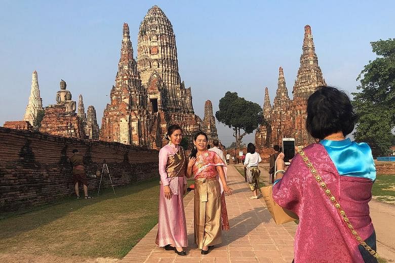 Women in traditional costumes posing for a picture last Thursday in ancient capital Ayutthaya amid rising interest in history, thanks to a popular soap opera .
