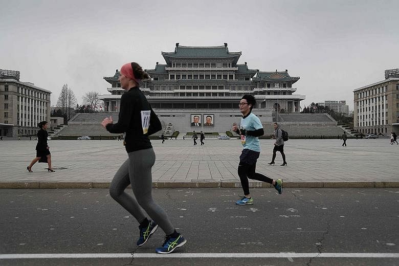 Competitors running through Kim Il Sung Square at the annual Pyongyang Marathon yesterday. The event, popular with Western tourists, drew less than half the number of foreign runners from last year.