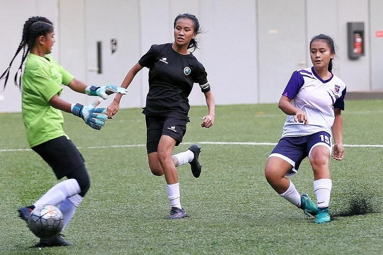 From top: Hong Kah's goalkeeper Nurul Radiatul and captain Nur Athirah are unable to stop Putri Nur Syaliza slotting home for her 19th goal of the campaign. Queensway's Daniah Fitriyah celebrating her goal with captain Dorcas Chu, who scored three.