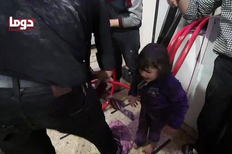 An image from a video released by the Douma City Coordination Committee showing volunteers spraying a girl with water at a makeshift hospital after an alleged chemical attack last Saturday on the town of Douma, which was then still occupied by rebel 
