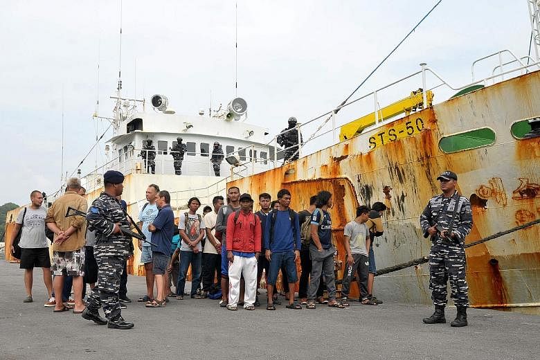 Indonesian military guarding the crew of the alleged "slave ship", who are believed to have been forced to work without pay, at the naval port of Sabang in Aceh province. Last Friday, the boat was captured following a dramatic high seas chase after t