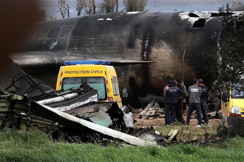 Rescuers at the wreckage of the crashed plane. The Ilyushin IL-76 transport plane was bound for Tindouf in south-west Algeria.