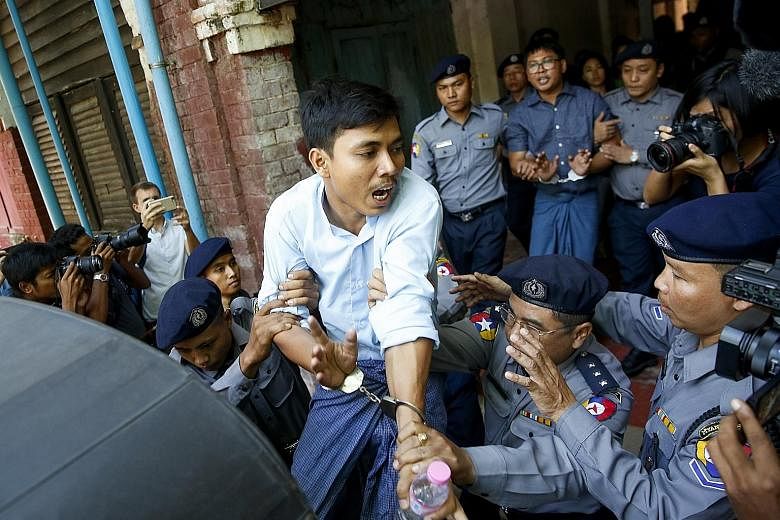 Reuters journalists Kyaw Soe Oo (in front) and Wa Lone being led away after their hearing in Yangon yesterday - when a judge rejected a request for the dismissal of a case against them. They are accused of possessing secret government papers.