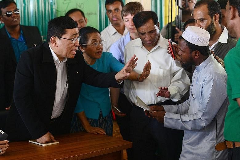 Myanmar Social Welfare Minister Win Myat Aye (left) talking to Rohingya refugees at the Kutupalong refugee camp in south-east Bangladesh yesterday. It was the first such visit by a top Myanmar official.