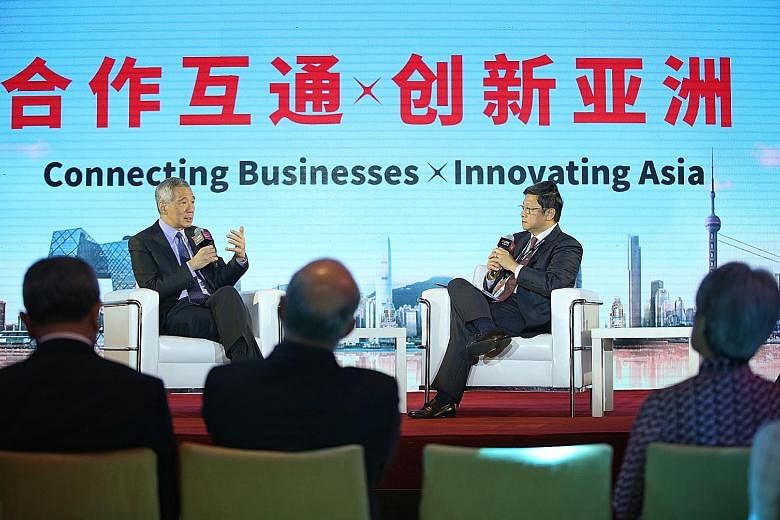 Prime Minister Lee Hsien Loong speaking at DBS Asian Insights Conference's Leadership Dialogue in Shanghai yesterday, moderated by Mr Robin Hu, head of Temasek's sustainability and stewardship group.