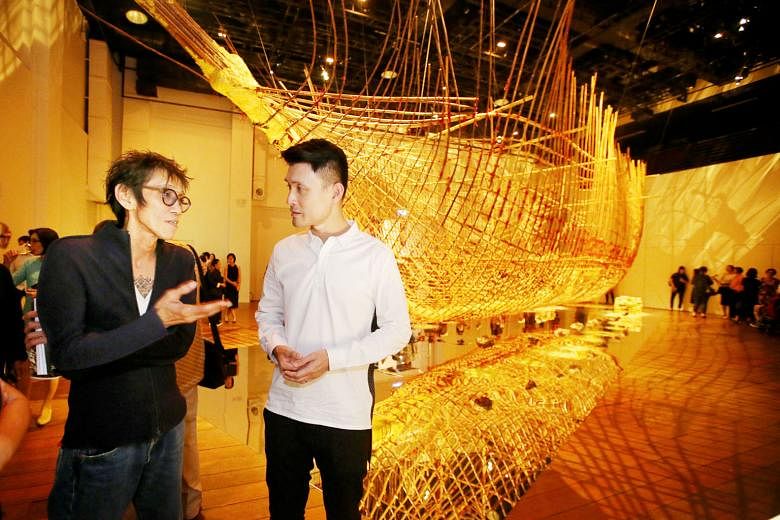 Artist Zai Kuning (left) discussing the artwork, Dapunta Hyang: Transmission Of Knowledge, with Parliamentary Secretary Baey Yam Keng, at the opening of the exhibition in Mohamed Sultan Road yesterday. The 17m-long skeletal ship was built for Singapo