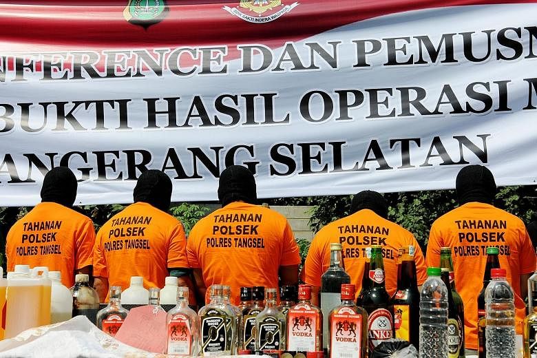 Suspects arrested for producing and selling illegal homemade alcohol were put on parade by Indonesian police during a public display in South Tangerang, on the outskirts of the Indonesian capital Jakarta, yesterday. Thousands of booze bottles were de