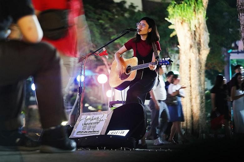Lasalle College of the Arts students Amirul Jamil and Jonquil Woon busking in Tampines. They team up to perform pop songs twice a week. Polytechnic student Marian Carmel performing outside The Cathay. She busks about three times a week and hopes to m