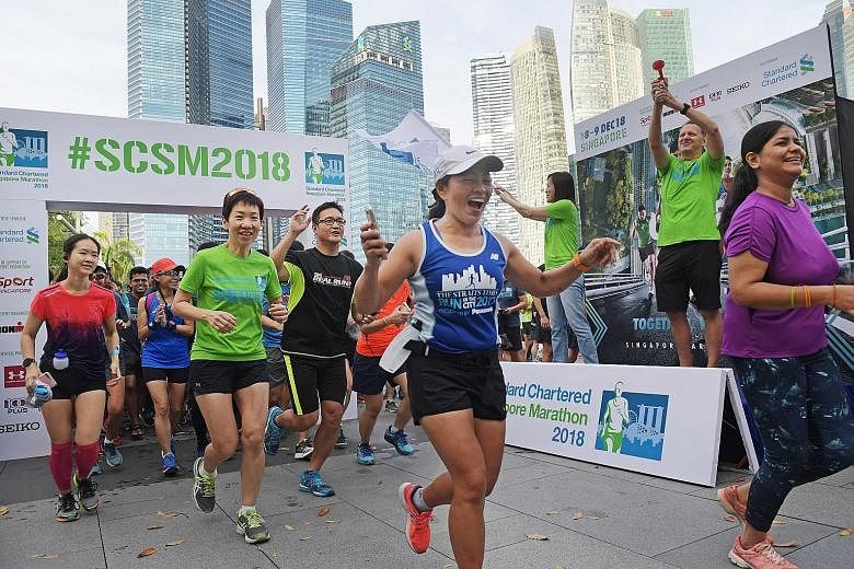 Minister Grace Fu (in green) leading participants on a 4km community run at Marina Bay to kick off this year's Standard Chartered Singapore Marathon. Flagging them off are Judy Hsu, Stanchart's CEO for Singapore and Asean markets, and Geoff Meyer, ma
