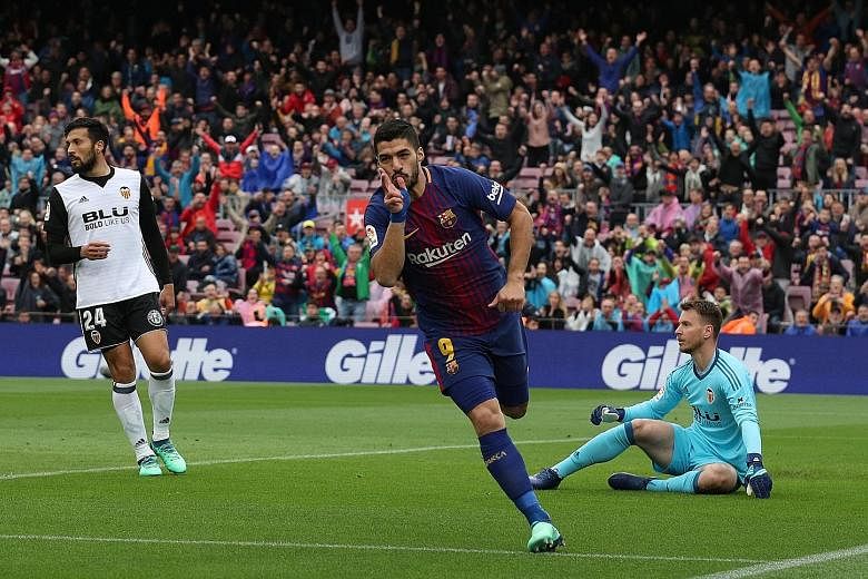 Barcelona striker Luis Suarez opening the scoring in the 15th minute against Valencia at the Nou Camp yesterday. The Spanish league leaders are now six games away from becoming the first LaLiga side to complete a 38-game unbeaten season.