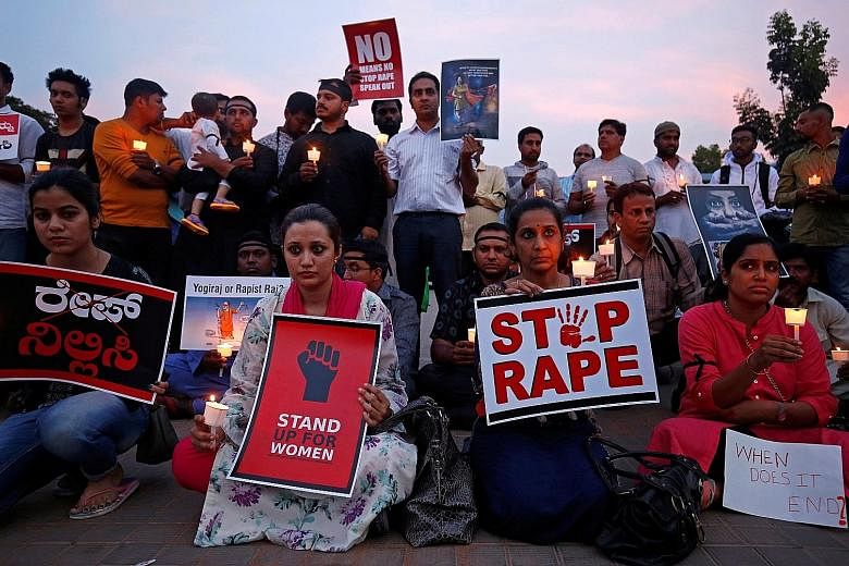 People protesting against the gang rape and murder of an eight-year-old girl in Jammu and Kashmir and the rape of a teenager in Uttar Pradesh at a candlelight vigil in Bengaluru, India, on Friday.