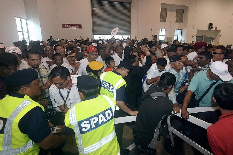 Taxi drivers rushing to collect their free RM800 fuel cards in Serdang, Selangor, last Friday, after the scheme was launched by Prime Minister Najib Razak. Thirty cabbies suffered minor injuries in the mad dash.