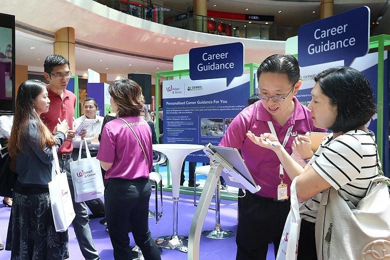 Career coaches (in purple) showing job seekers how to navigate the new MyCareersFuture.sg portal, which replaces the interface of the existing Jobs Bank for users. For now, employers will still post jobs on Jobs Bank, and the posts will be shown on t