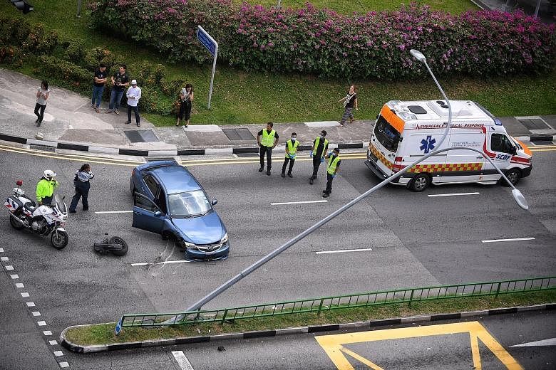 The car crashed into a road divider in Lorong 1 Toa Payoh and the impact dislodged a lamp post, causing it to nearly topple over.