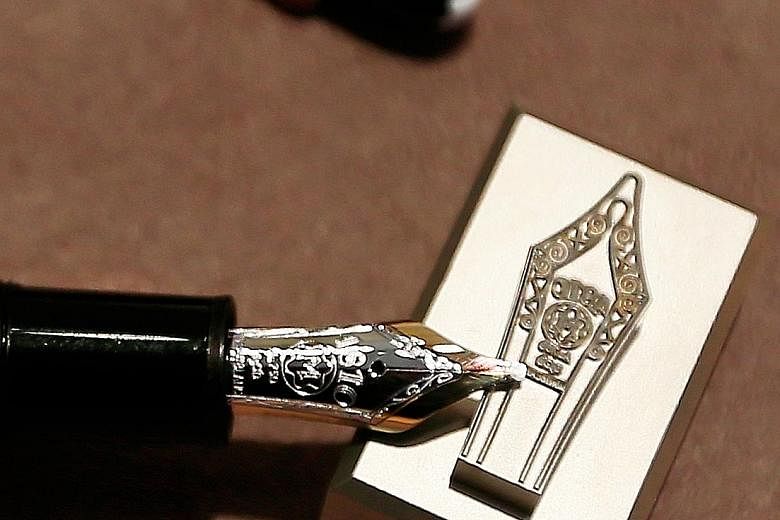 The writing instruments (above) from German luxury goods manufacturer Montblanc are often handcrafted with premium materials. South Africa-born craftsman Axel Nier (top) was in Singapore recently to showcase Montblanc's pen nibs, all of which are eng