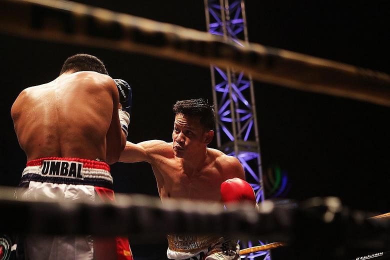 Singapore's Muhamad Ridhwan throwing a punch at Filipino Jeson Umbal during their International Boxing Organisation intercontinental featherweight title bout last night.