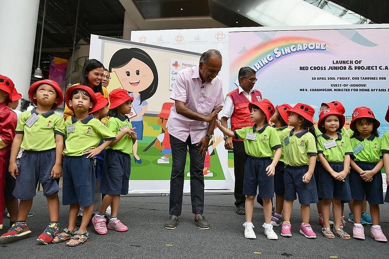 Law and Home Affairs Minister K. Shanmugam exchanging a high five with five-year-old Tan Ying Tong at Our Tampines Hub yesterday, at the launch of the Red Cross Junior club, a programme by the Singapore Red Cross and Kidz Meadow, which teaches five-t