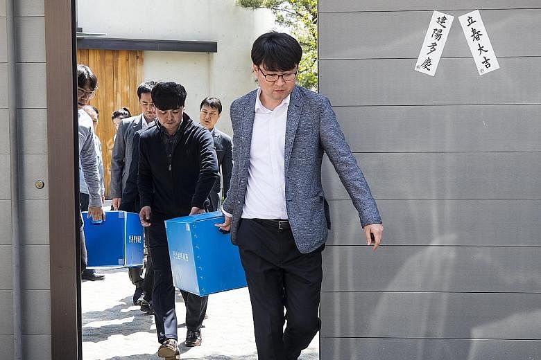 Customs investigators leaving Korean Air's main office in Seoul yesterday after a raid to search for evidence of smuggling.