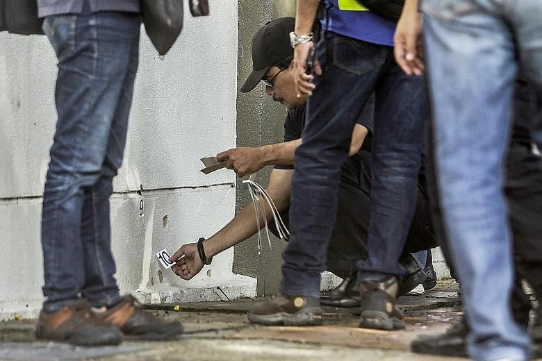 Malaysian forensic officers collecting evidence at the scene where Dr Fadi Mohammad al-Batsh (above) was killed in a drive-by motorcycle shooting in Kuala Lumpur yesterday.