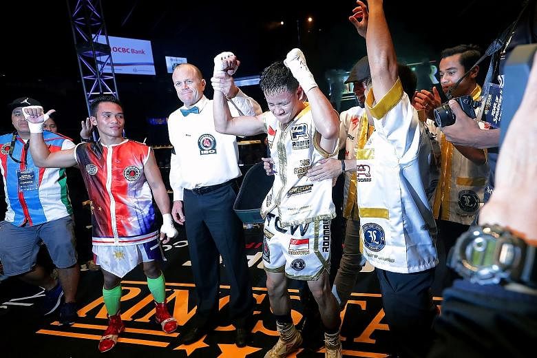 The referee raising Muhamad Ridhwan's hand as the winner after he scored a majority decision over Filipino Jeson Umbal at the Singapore Indoor Stadium on Friday night.