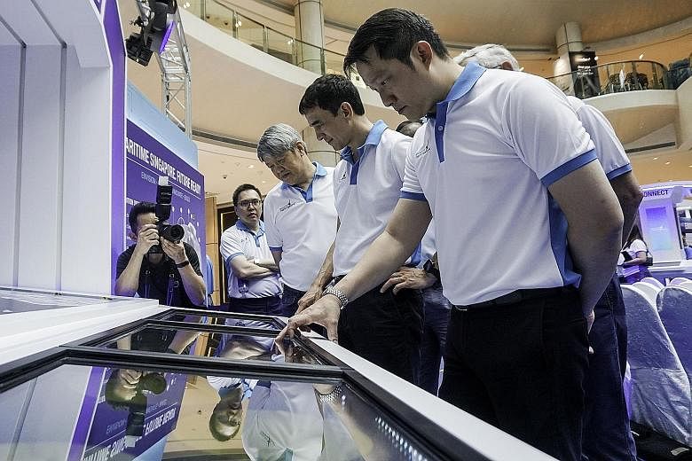 Senior Minister of State for Transport and Health Lam Pin Min (left) at a "Port of the Future" interactive display at the Singapore Maritime Week (SMW) Exhibition yesterday. The annual SMW officially started yesterday, with more than 30,000 maritime 