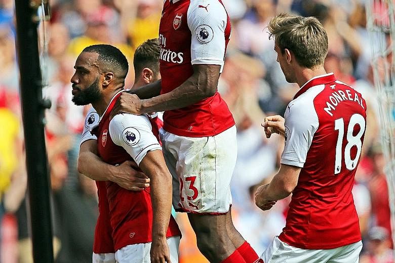 Alexandre Lacazette (extreme left) scored two goals in four minutes to close out a 4-1 Premier League win against West Ham yesterday.