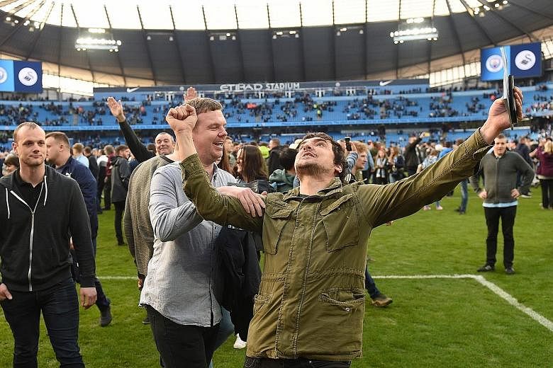An exuberant Manchester City fan celebrating on the Etihad Stadium pitch after the 5-0 Premier League win over Swansea. The Football Association is investigating the pitch invasion but City manager Pep Guardiola is relaxed about the prospect of a pen