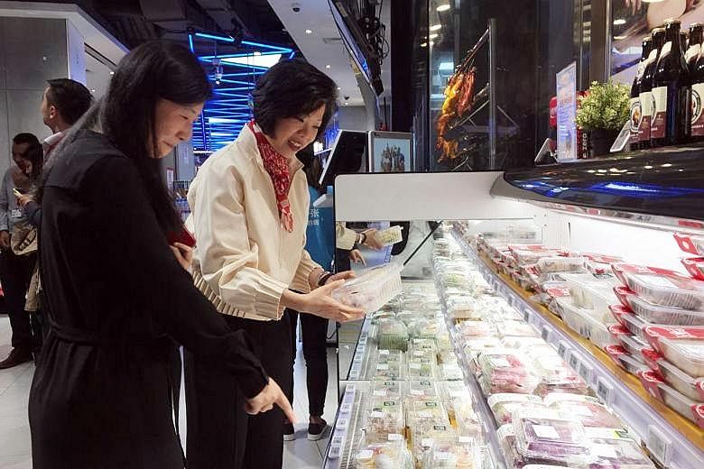Senior Minister of State for Trade and Industry Sim Ann visiting one of Alibaba's Hema supermarkets in downtown Shanghai on Monday. Shoppers in Hema stores cannot pay cash but must use Alipay, Alibaba's mobile payment app.