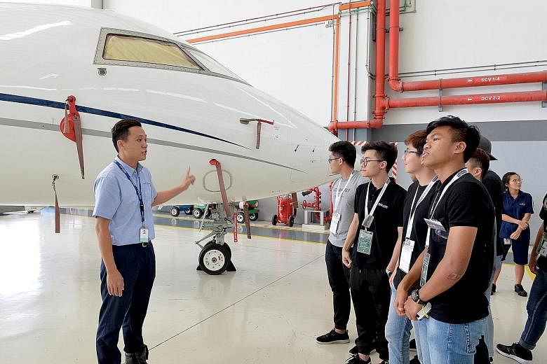 Hawker Pacific's aviation staff Alvin Wong giving a tour to Ngee Ann Polytechnic's students during Aerospace Day @ Seletar Aerospace Park. Students witnessed maintenance and paint jobs done on planes, and also tried their hand at drone-flying, glider 